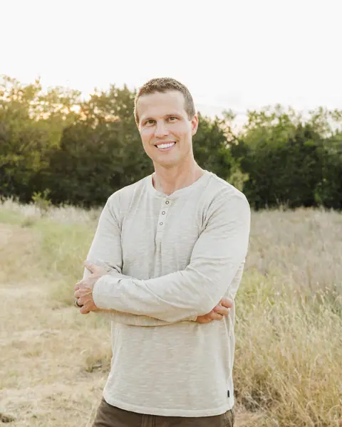 Daniel Hogenson, founder of RenovatePros, standing in a field with his arms crossed
