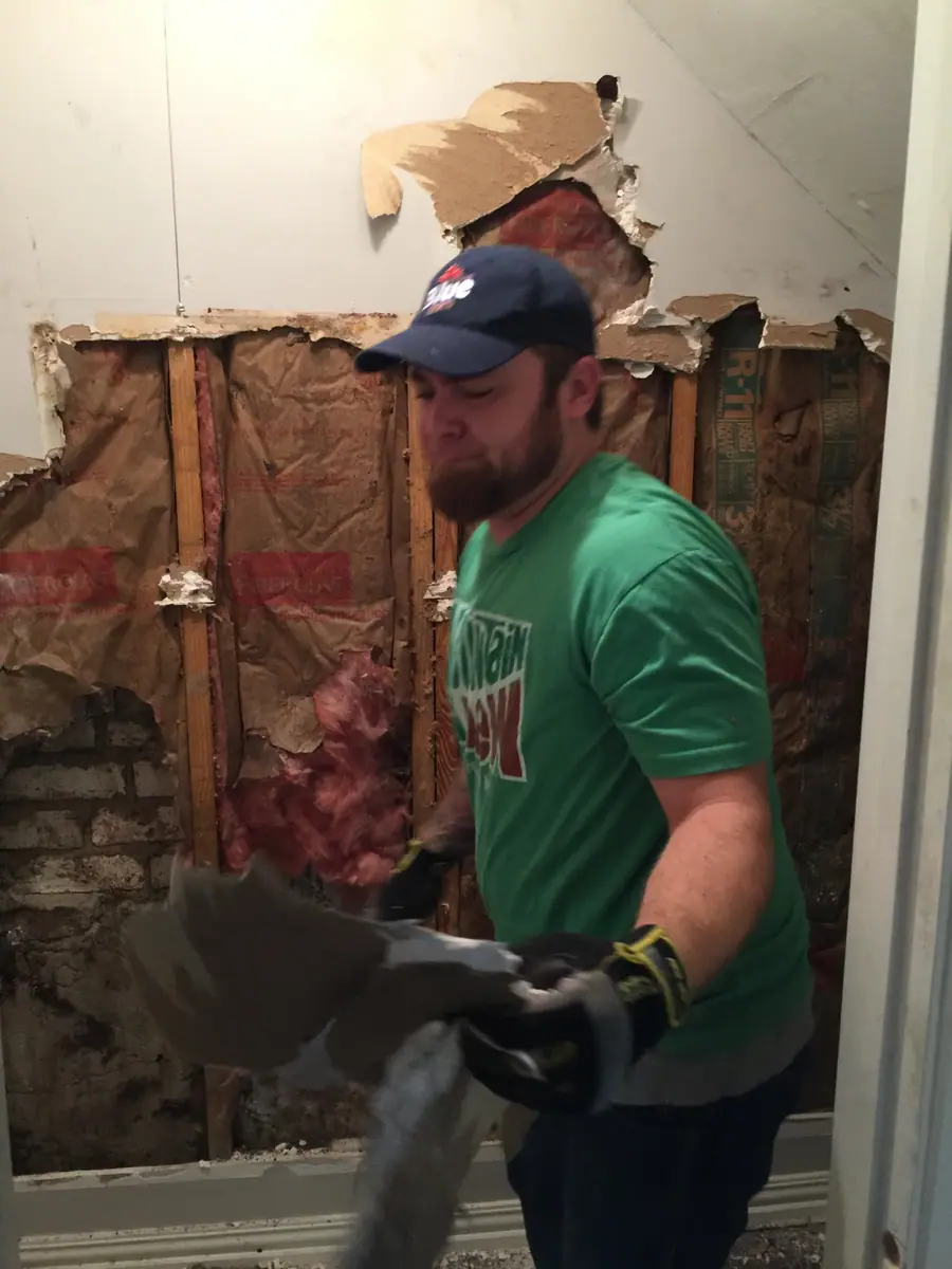 Harvey damage demo: a RenovatePros crew member taking out storm-damaged wall