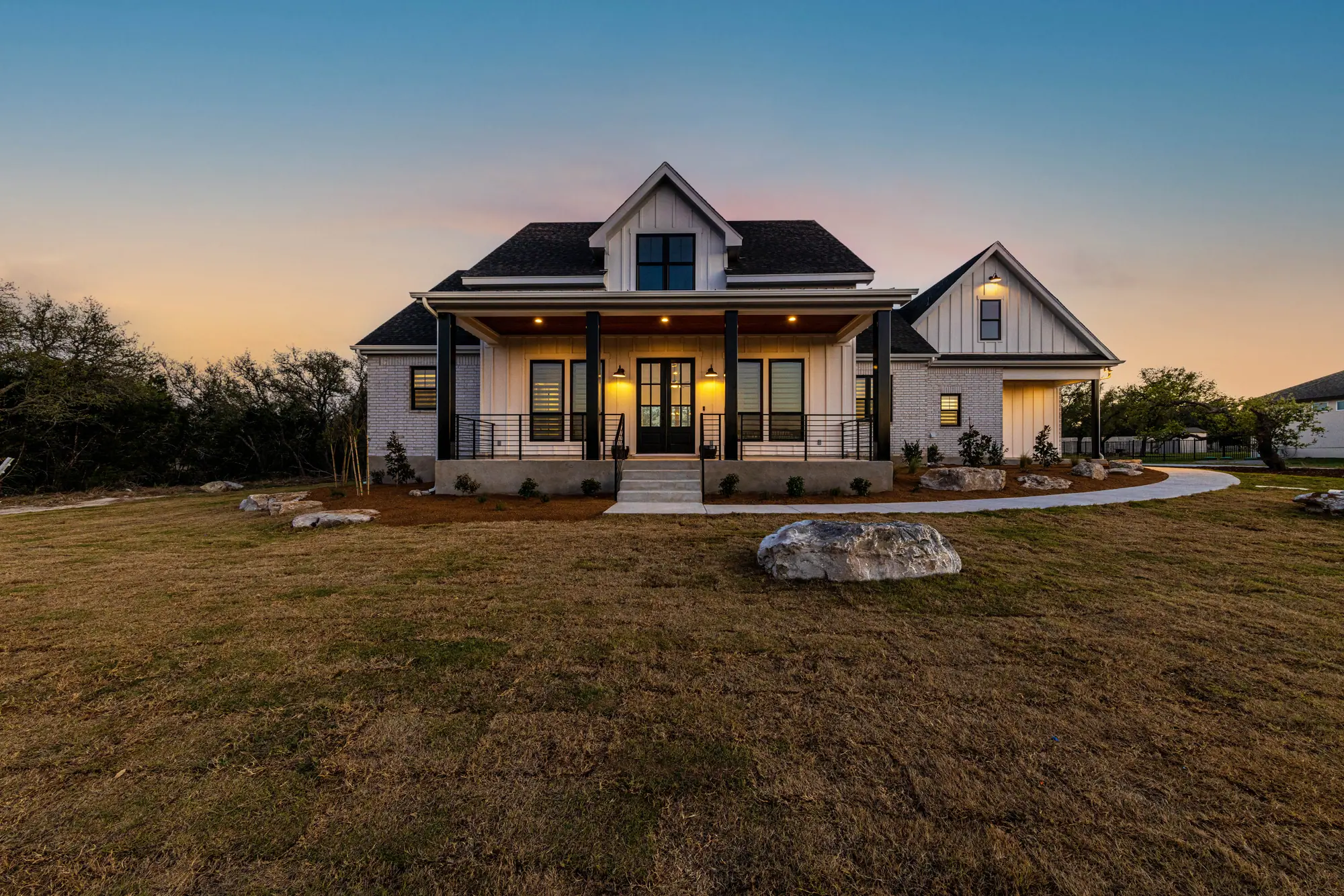 Farmhouse Hill Country Retreat at dusk, a home built by RenovatePros