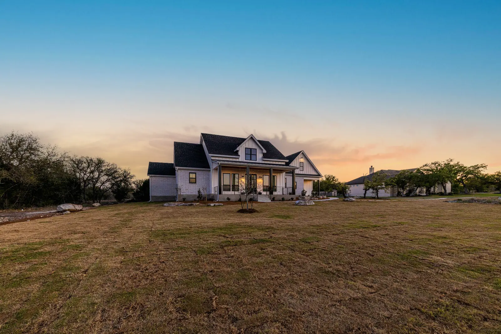 Exterior at dusk, Farmhouse Hill Country Retreat (RenovatePros project)