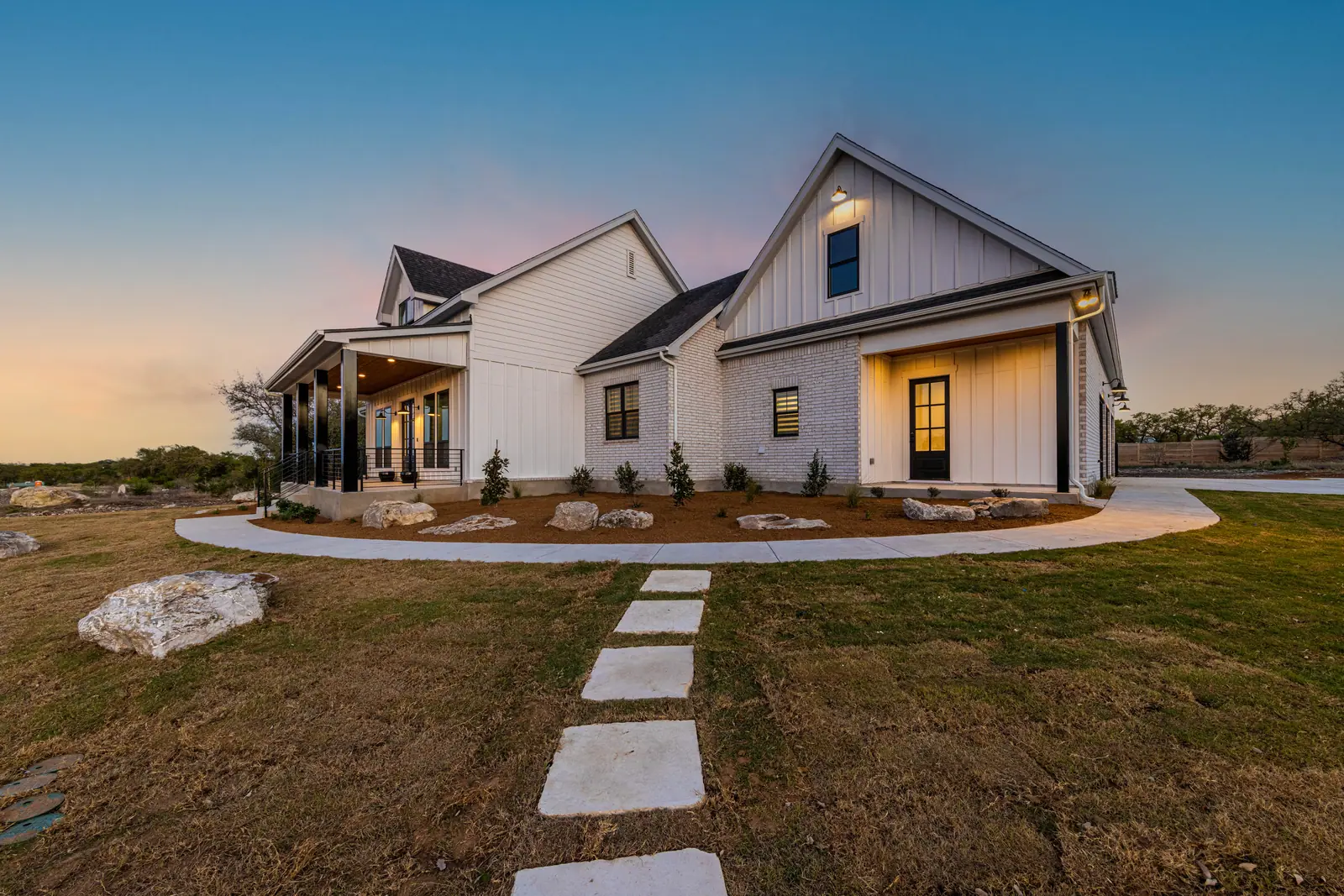 Exterior at dusk, Farmhouse Hill Country Retreat (RenovatePros project)