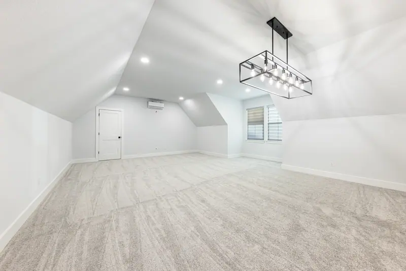 Upstairs bonus room with carpet and a modern light fixture, Farmhouse Hill Country Retreat (RenovatePros project)