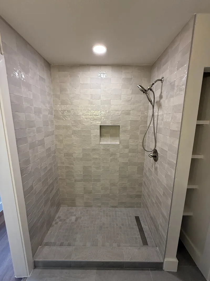 Curbless tiled shower with a linear drain and a wall niche, Oak Hill-area remodel by RenovatePros