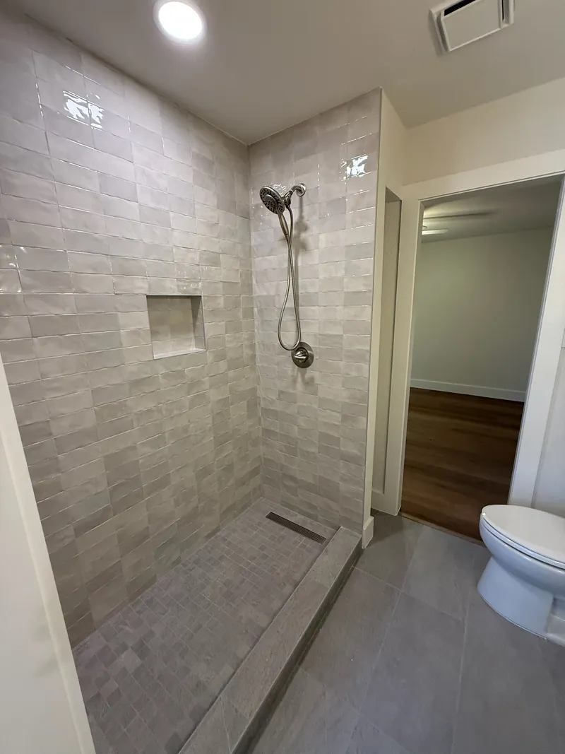 Tiled walk-in shower beside the toilet, Oak Hill-area remodel by RenovatePros