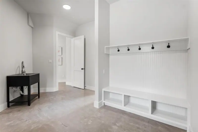 Mudroom with a built-in bench and coat hooks, Round Mountain Modern Farmhouse (RenovatePros project)