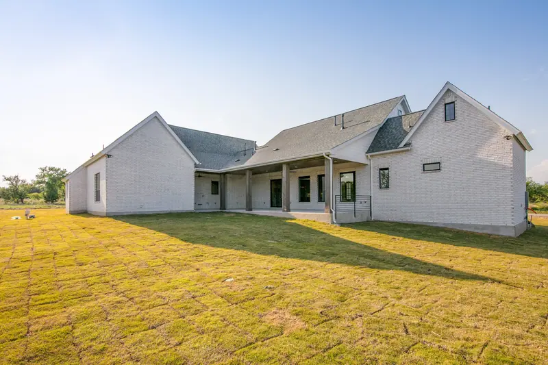 Back of the home with a long covered patio, Spicewood Modern Farmhouse (RenovatePros project)
