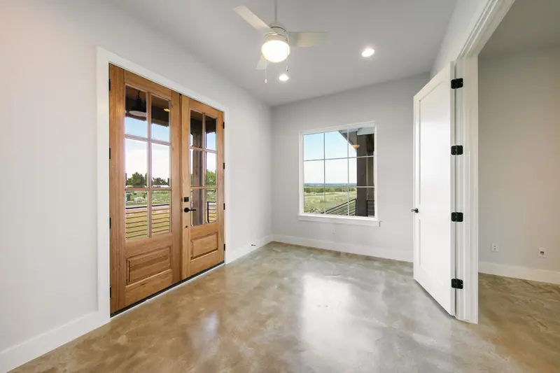 Bedroom with wood French doors and a window, Spicewood Modern Farmhouse (RenovatePros project)