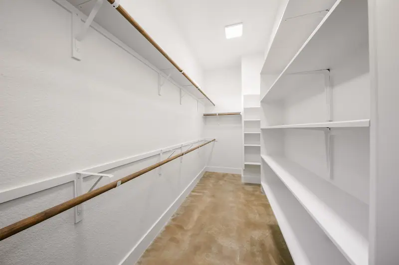 Walk-in closet with long hanging rods and shelves, Spicewood Modern Farmhouse (RenovatePros project)