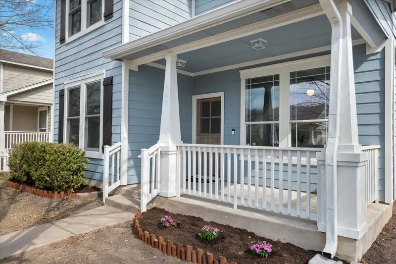 Front porch with white columns and railings, and fresh landscaping, Two-Story Home Remodel, 2026 (RenovatePros project)