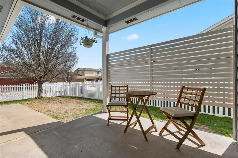 Covered back patio with a slatted privacy screen and bistro chairs, Two-Story Home Remodel, 2026 (RenovatePros project)