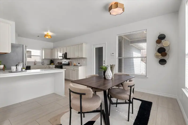 Kitchen island and dining table with a gold ceiling light, Two-Story Home Remodel, 2026 (RenovatePros project)