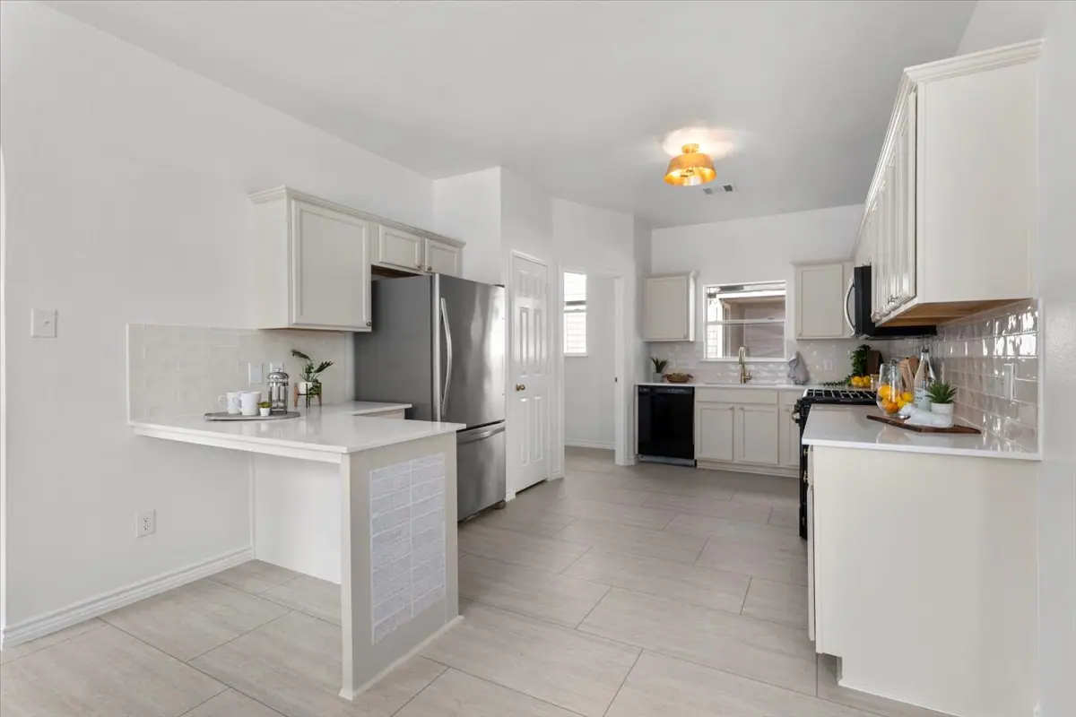Kitchen with white shaker cabinets, white counters, a stainless refrigerator and an island, Two-Story Home Remodel, 2026 (RenovatePros project)