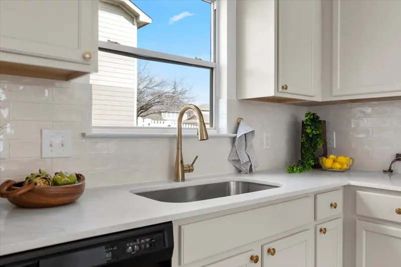 Kitchen sink with a gold faucet, white counter and glossy tile backsplash, Two-Story Home Remodel, 2026 (RenovatePros project)