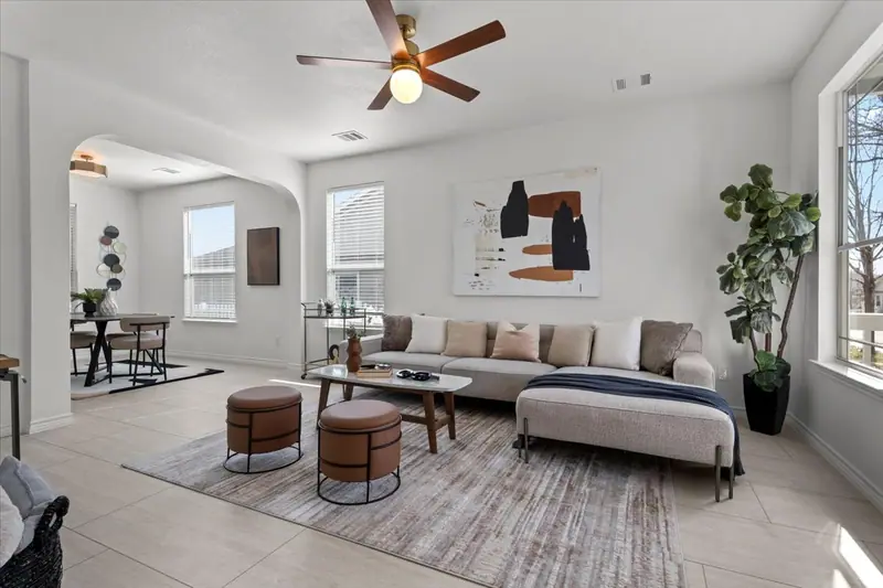 Living room with a sofa and ottomans, open to the dining area, Two-Story Home Remodel, 2026 (RenovatePros project)