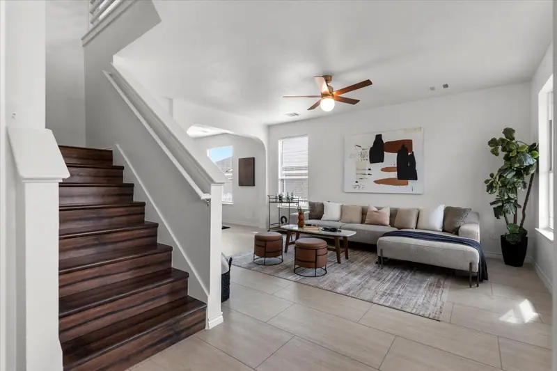Staircase with wood treads beside the living room, Two-Story Home Remodel, 2026 (RenovatePros project)
