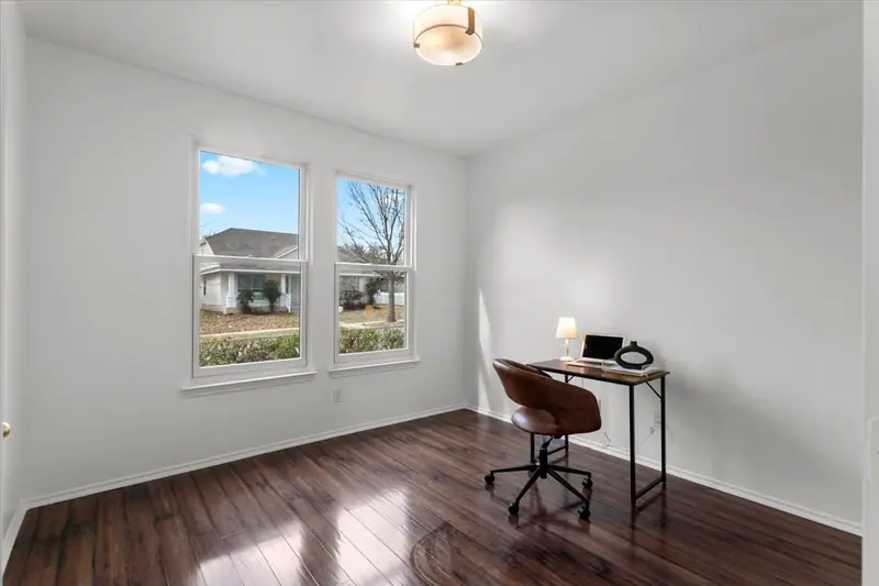 Upstairs room with dark wood-look floors and a desk by the windows, Two-Story Home Remodel, 2026 (RenovatePros project)