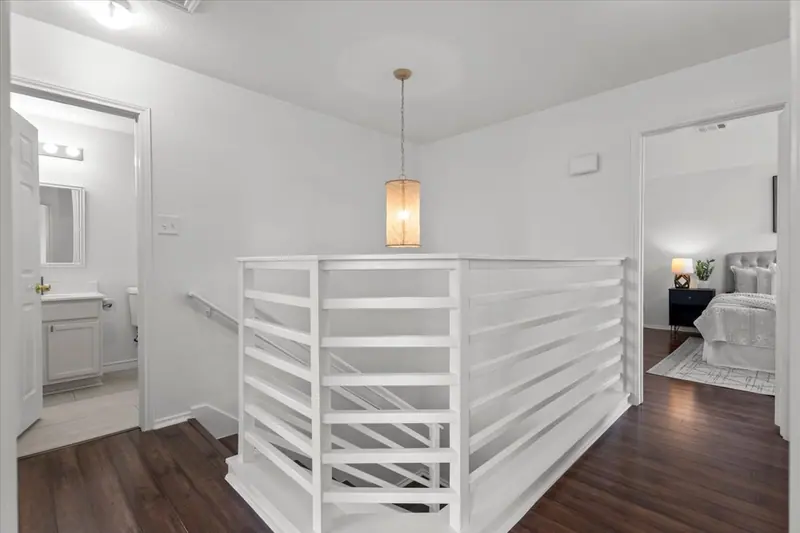 Upstairs landing with a white slatted stair railing and a pendant light, Two-Story Home Remodel, 2026 (RenovatePros project)
