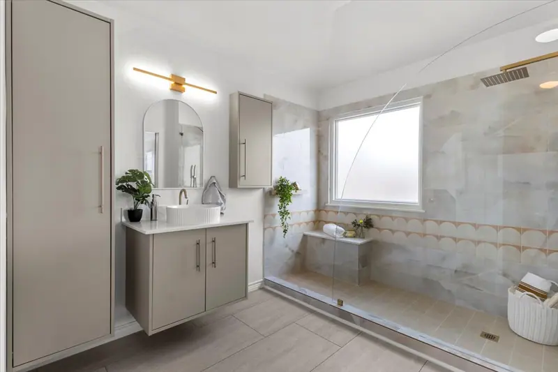 Primary bathroom with a marble-look walk-in shower and a scalloped tile border, Two-Story Home Remodel, 2026 (RenovatePros project)