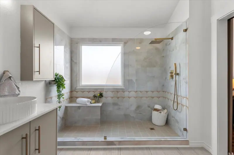 Walk-in shower with a bench, gold fixtures and a frosted window, Two-Story Home Remodel, 2026 (RenovatePros project)